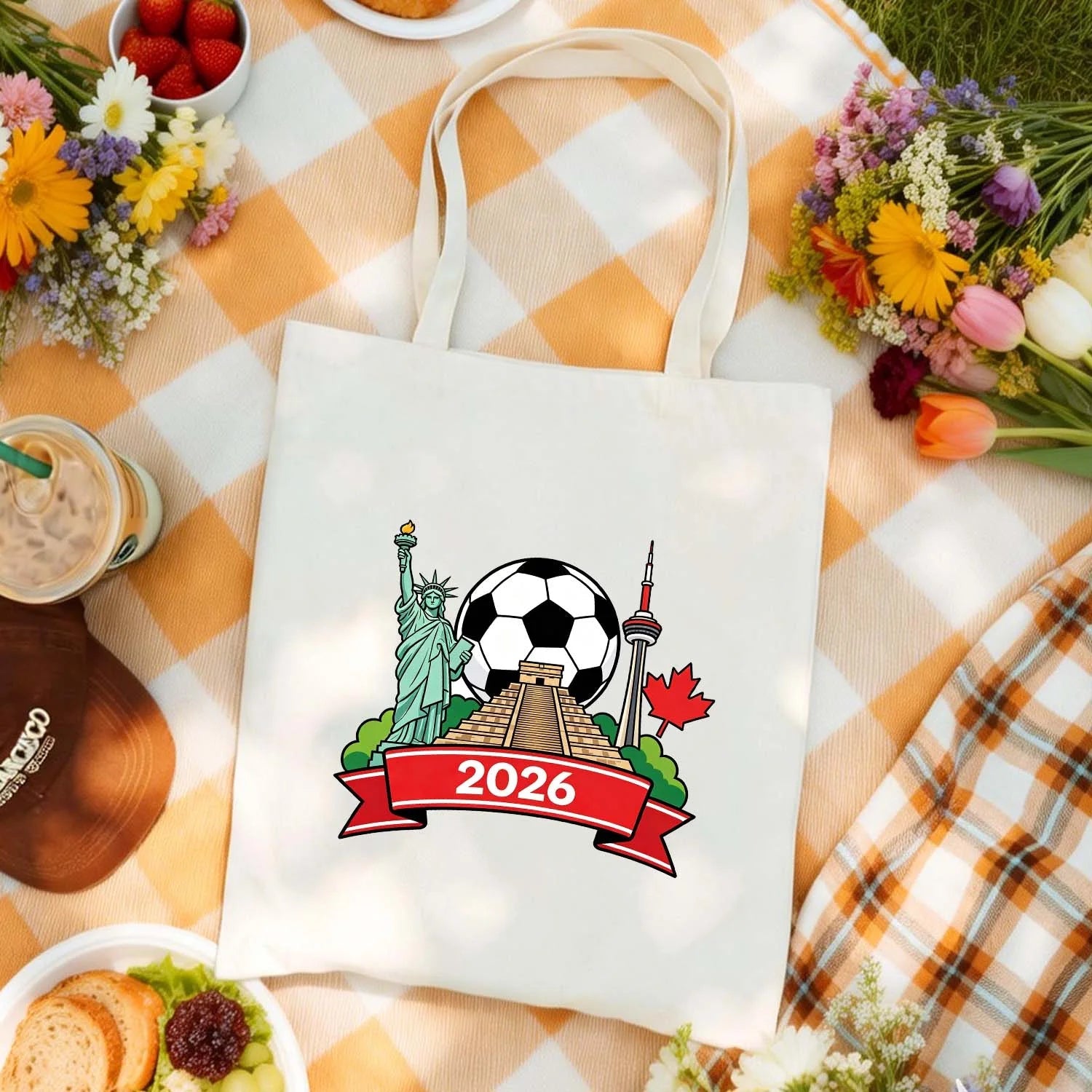Model carrying 2026 World Cup themed tote bag with USA Statue of Liberty, Mexico pyramid, Canada CN Tower and soccer ball design, cotton canvas bag